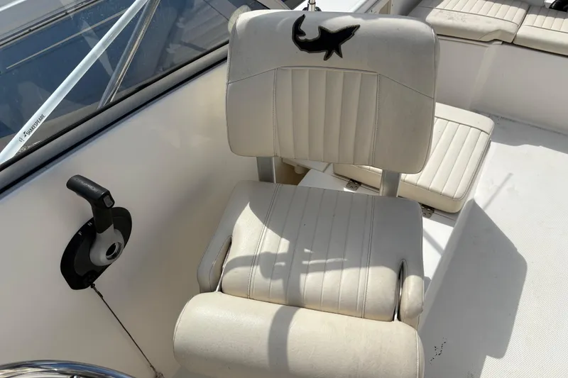 Slide: The Image of 2006 Mako 216 Dual Console boat seat with shark logo and control lever. - 14