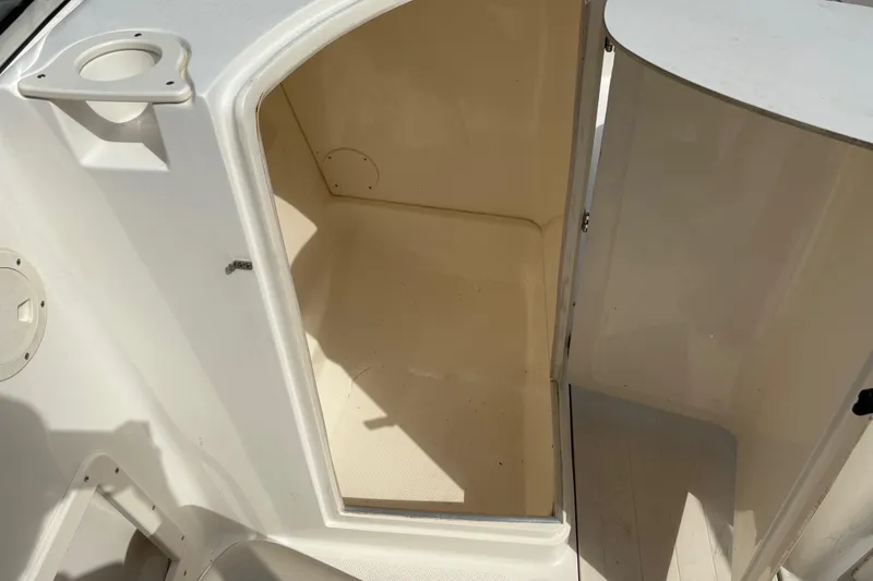 Slide: The Image of Open storage compartment on a 2006 Mako 216 Dual Console boat. - 16