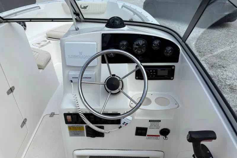 Slide: The Image of 2006 Mako 216 Dual Console boat dashboard with steering wheel and navigation instruments. - 17