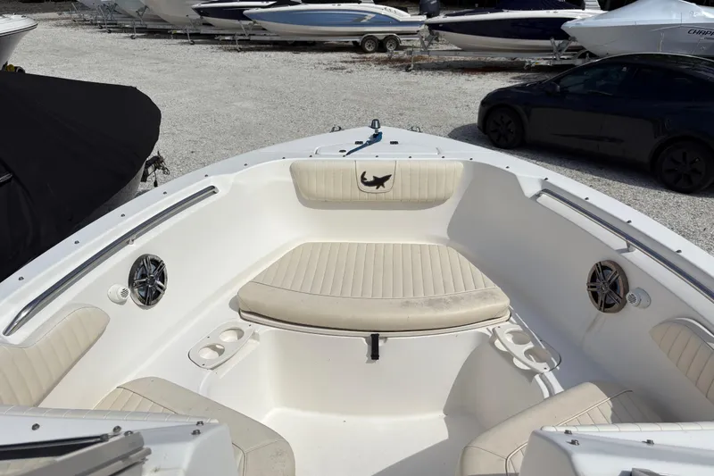 Slide: The Image of 2006 Mako 216 Dual Console boat interior with seating and cup holders, parked among other boats. - 19