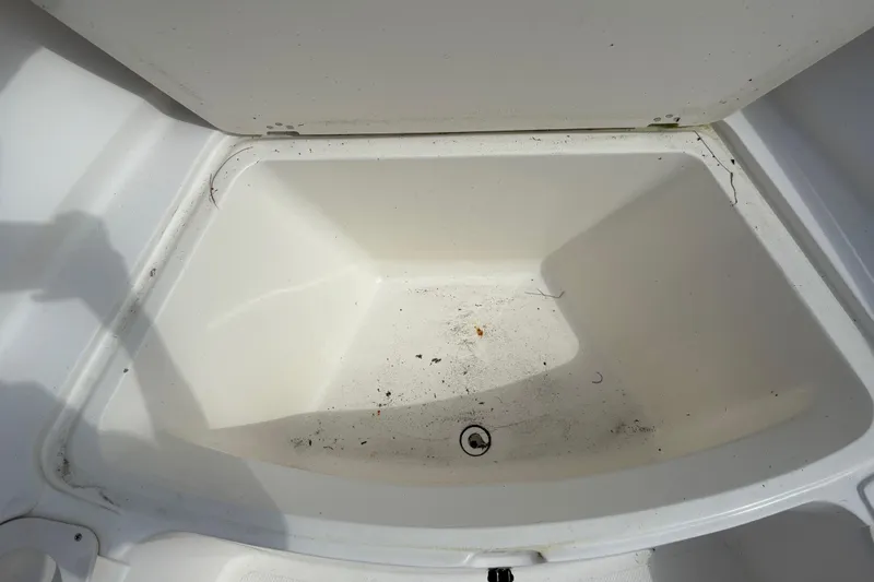 Slide: The Image of Open storage compartment in 2006 Mako 216 Dual Console boat, showing interior space. - 20