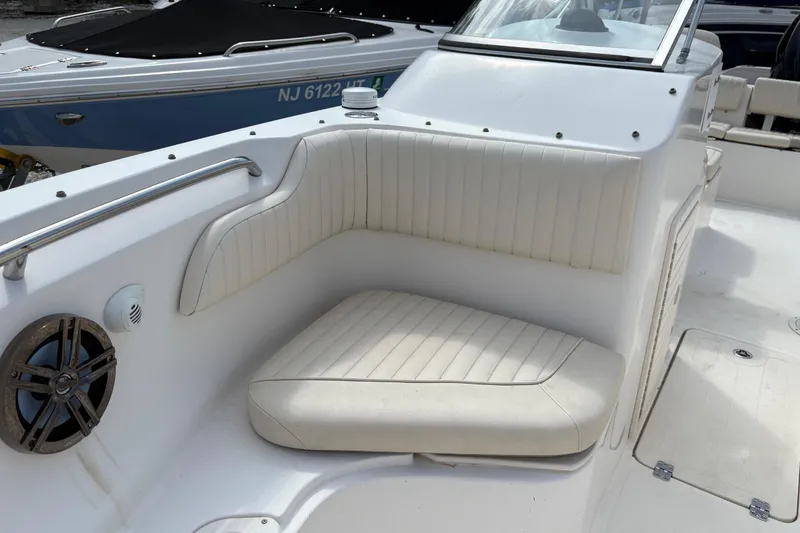 Slide: The Image of 2006 Mako 216 Dual Console boat with white cushioned seating and speaker. - 21