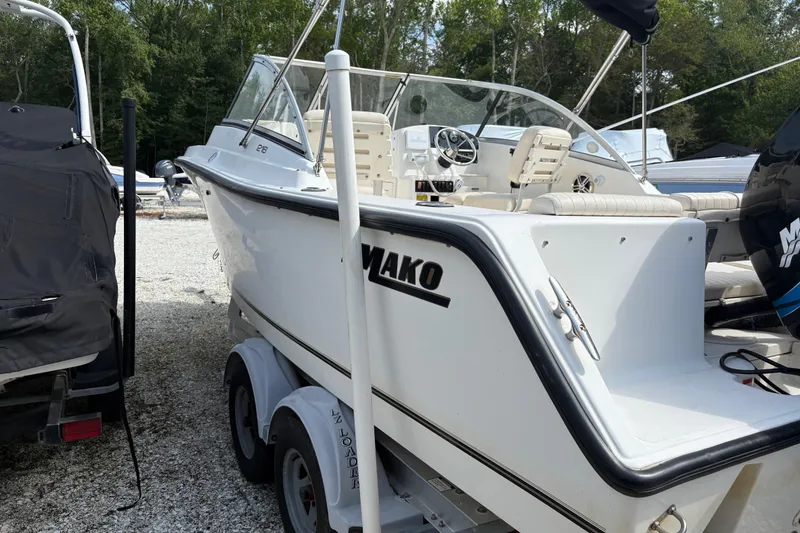 Slide: The Image of 2006 Mako 216 Dual Console boat on trailer, parked outdoors with trees in background. - 5