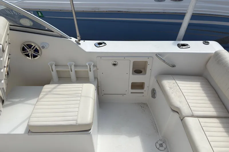 Slide: The Image of 2006 Mako 216 Dual Console boat interior with white seating and storage compartments. - 9