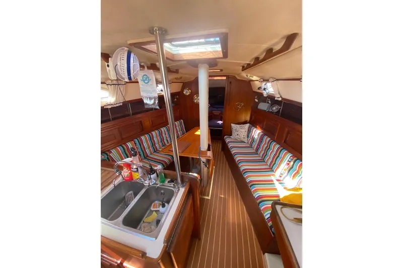 Slide: The Image of Interior of 1992 Pacific Seacraft Ericson 34 sailboat with colorful striped seating and wooden finishes. - 19