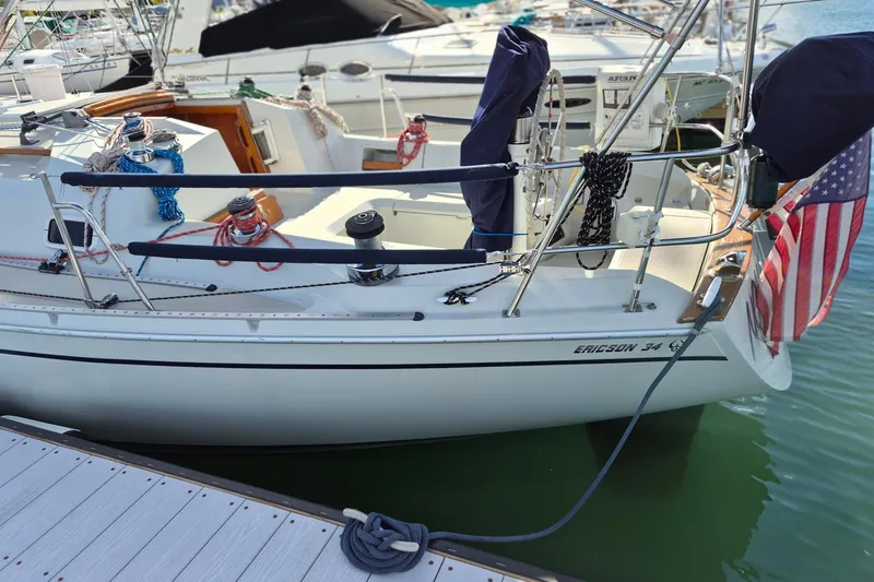 Slide: The Image of 1992 Pacific Seacraft Ericson 34 sailboat docked with American flag displayed. - 2