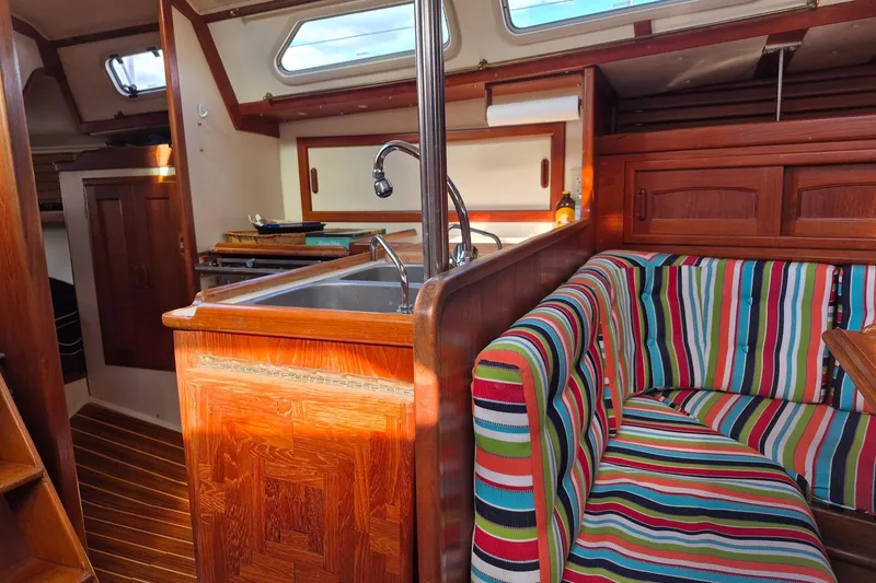 Slide: The Image of Interior of 1992 Pacific Seacraft Ericson 34 sailboat with colorful striped seating and wooden cabinetry. - 22