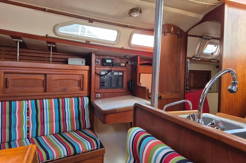 Slide: The Image of Interior of 1992 Pacific Seacraft Ericson 34 sailboat with colorful striped seating and wooden cabinetry. - 24