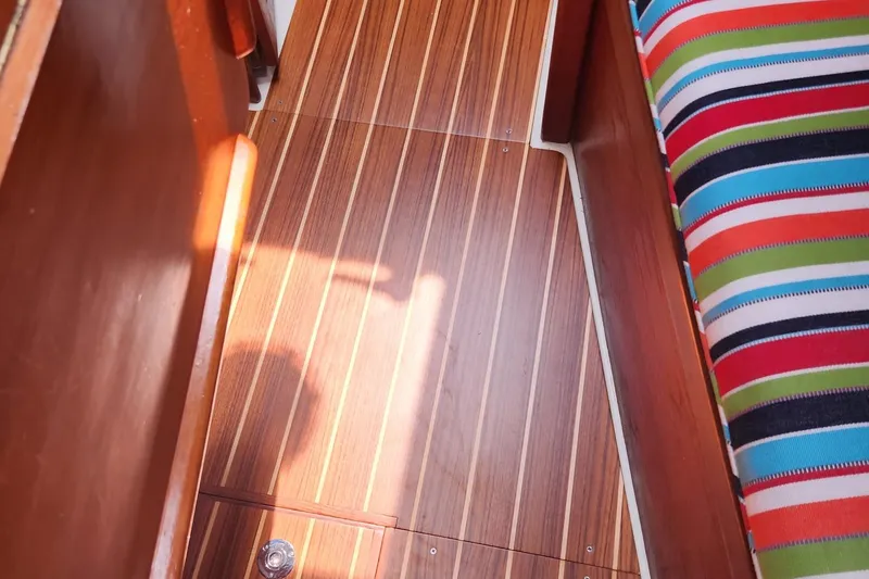 Slide: The Image of Teak flooring and colorful seating in 1992 Pacific Seacraft Ericson 34-2 sailboat interior. - 28