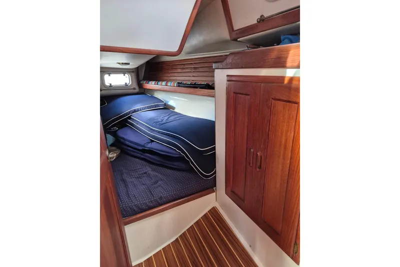 Slide: The Image of Cozy cabin interior of 1992 Pacific Seacraft Ericson 34 sailboat with wooden cabinetry and blue bedding. - 38