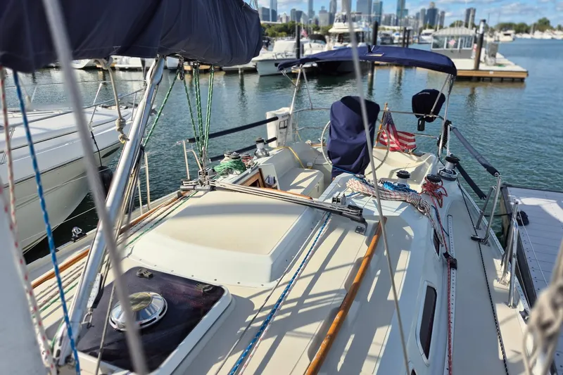 Slide: The Image of 1992 Pacific Seacraft Ericson 34 sailboat docked at marina, with city skyline in background. - 5