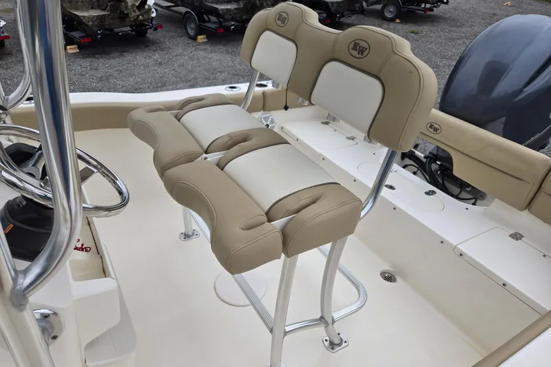 Slide: The Image of 2018 Key West 203 FS boat interior with beige and white seating, steering wheel, and engine. - 16