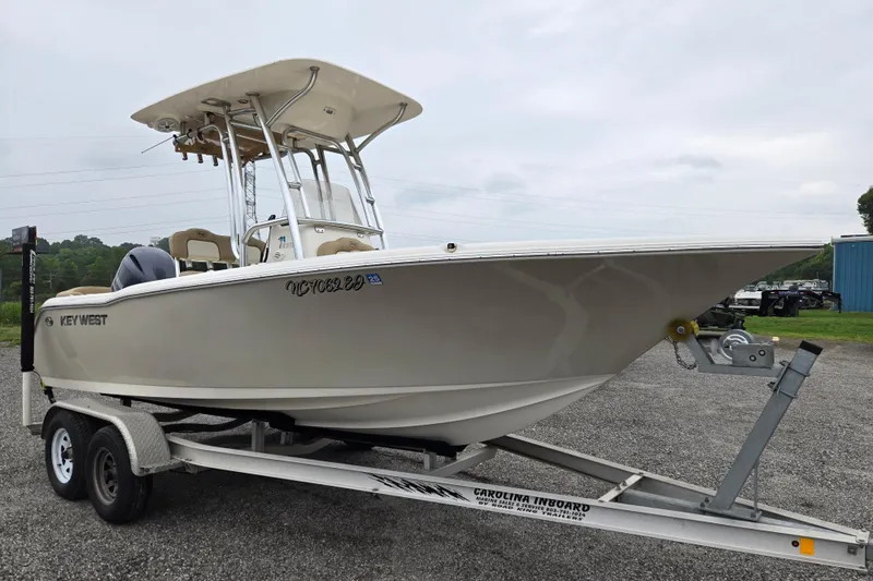 Slide: The Image of 2018 Key West 203 FS boat on trailer, parked outdoors on gravel. - 2