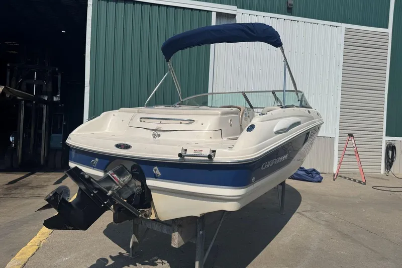 Slide: The Image of 2001 Chaparral 220 SSi boat with blue canopy in a marina setting. - 3
