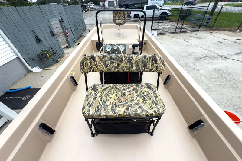 Slide: The Image of 2026 Carolina Skiff E21 DLX CC boat interior with camo seating and steering console. - 11