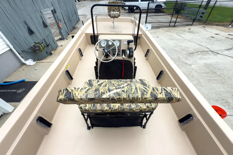 Slide: The Image of 2026 Carolina Skiff E21 DLX CC boat interior with camo seating and steering console. - 12