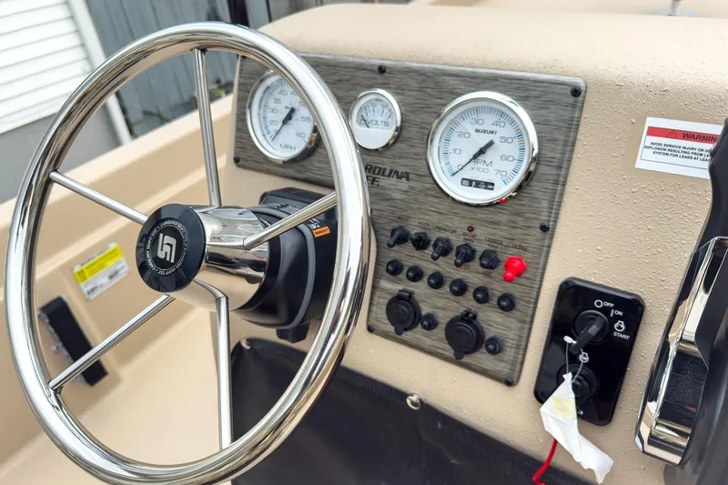 Slide: The Image of Steering console of 2026 Carolina Skiff E21 DLX CC with gauges and controls. - 14