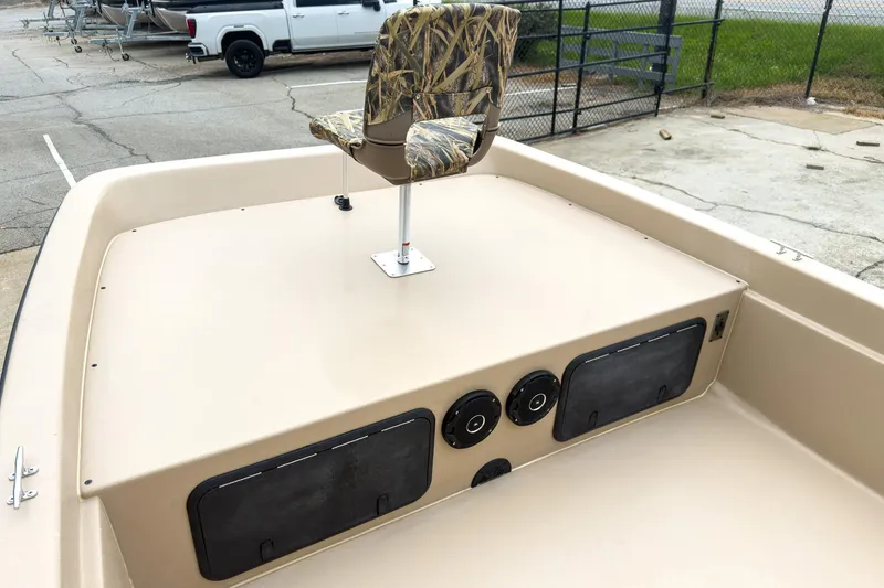 Slide: The Image of 2026 Carolina Skiff E21 DLX CC boat with camo seat and storage compartments. - 26