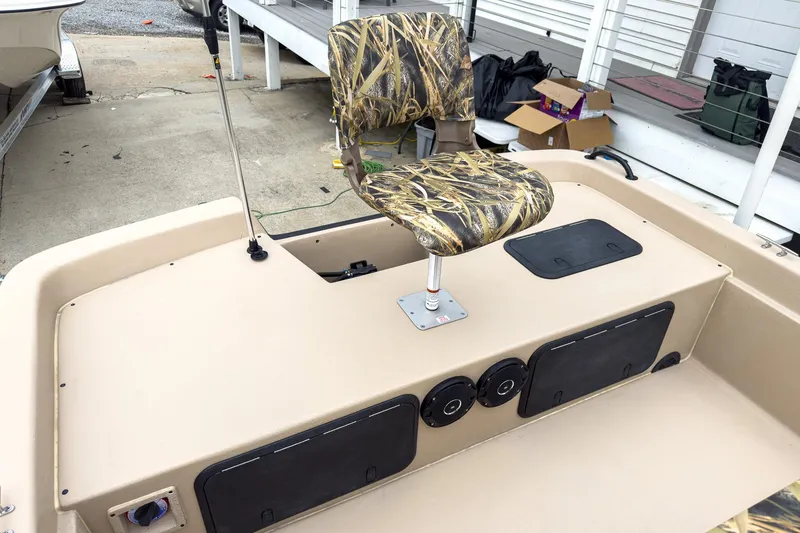Slide: The Image of 2026 Carolina Skiff E21 DLX CC boat with camo seat and storage compartments. - 9