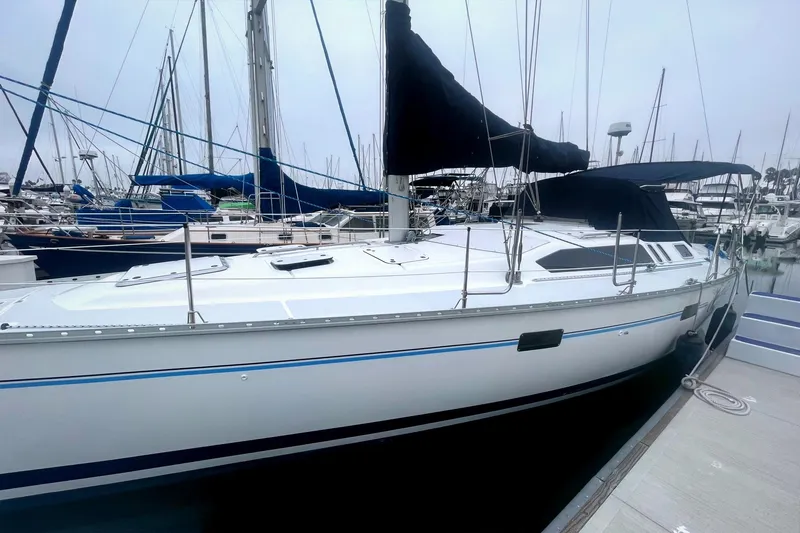 Slide: The Image of 1993 Hunter 40.5 sailboat docked at marina, featuring sleek design and black sail cover. - 10