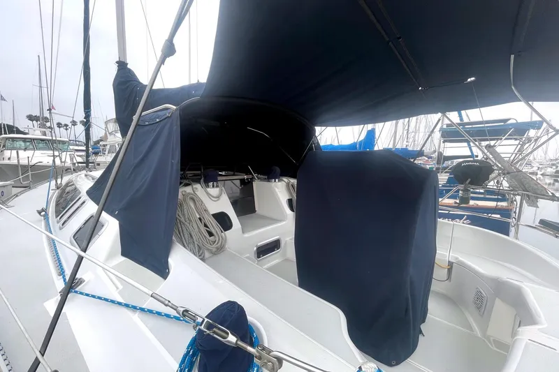 Slide: The Image of 1993 Hunter 40.5 sailboat cockpit with blue covers and marina background. - 15