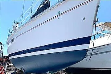 Slide: The Image of 1993 Hunter 40.5 sailboat with blue and white hull, docked on land. - 21