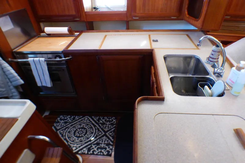 Slide: The Image of Interior of 1993 Hunter 40.5 yacht kitchen with sink, stove, and wooden cabinetry. - 25