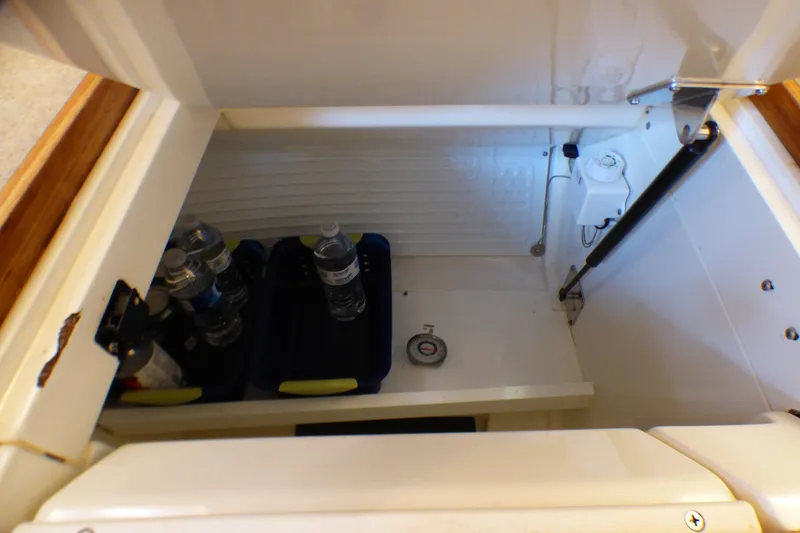 Slide: The Image of Storage compartment in a 1993 Hunter 40.5 yacht, containing water bottles and a thermometer. - 28