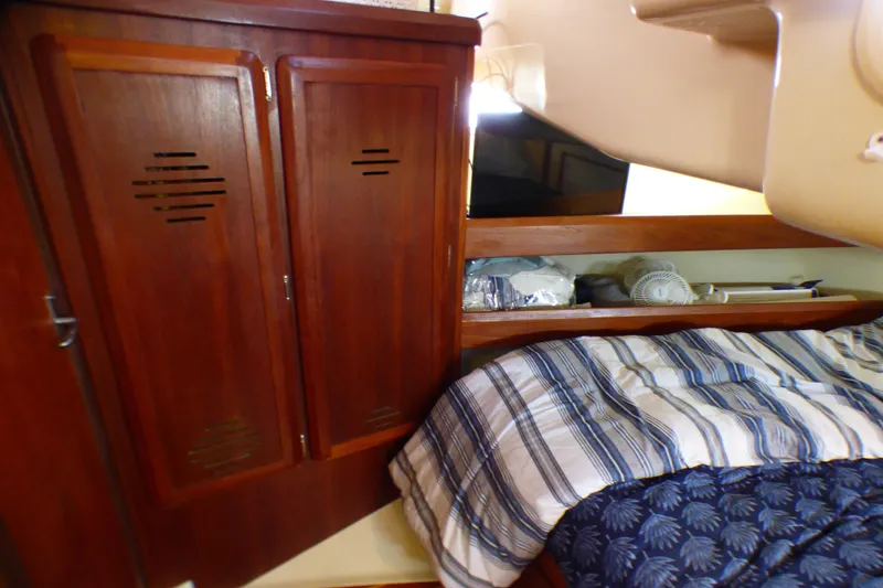 Slide: The Image of Cozy cabin interior of 1993 Hunter 40.5 sailboat with wooden cabinets and striped bedding. - 45
