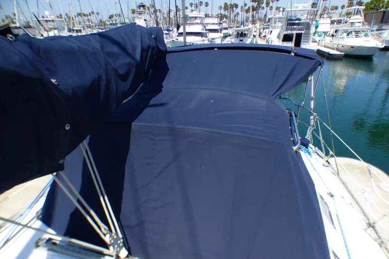 Slide: The Image of 1993 Hunter 40.5 sailboat with blue canvas cover in marina setting. - 69