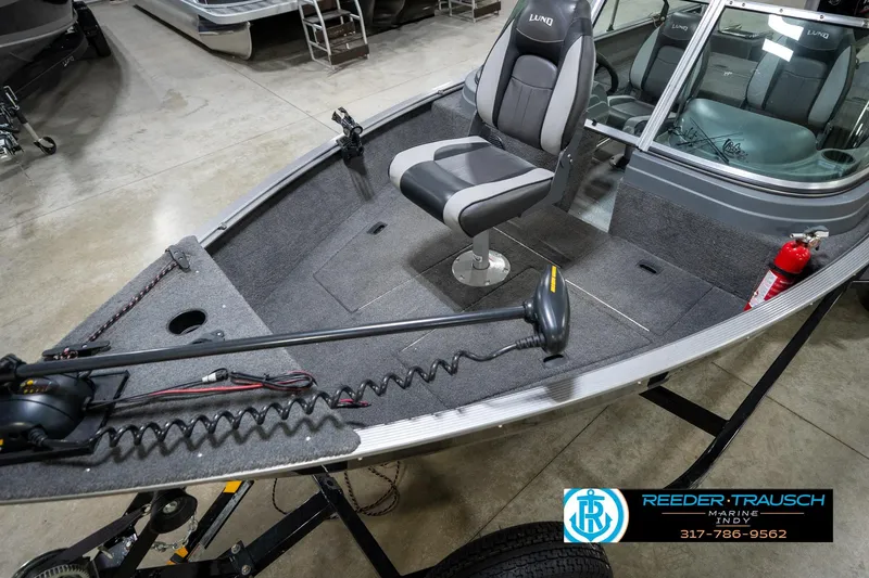 Slide: The Image of 2014 Lund 1650 Rebel XS boat interior with seating and equipment, displayed in a showroom. - 12