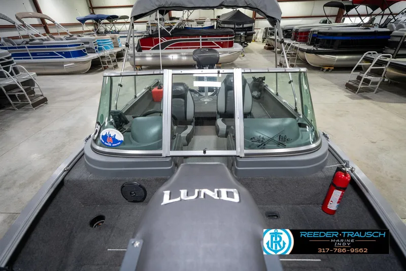 Slide: The Image of 2014 Lund 1650 Rebel XS boat in showroom with other pontoon boats. - 19