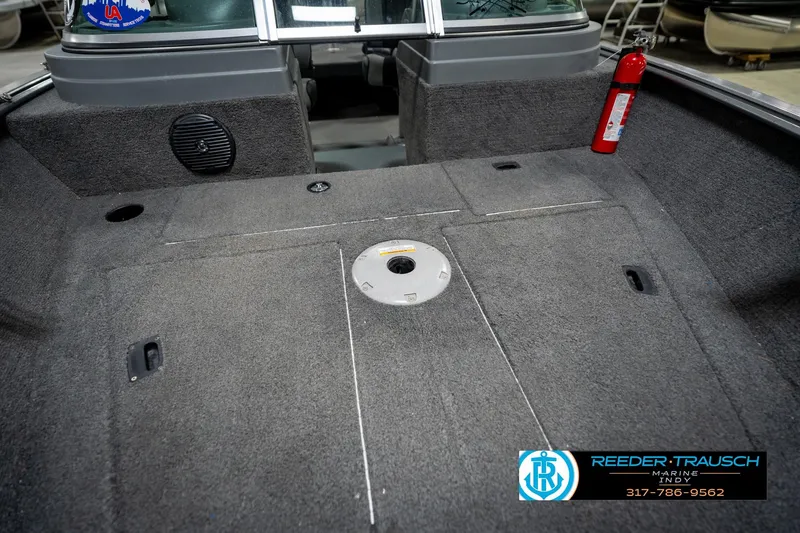 Slide: The Image of 2014 Lund 1650 Rebel XS boat interior with carpeted deck and fire extinguisher. - 22