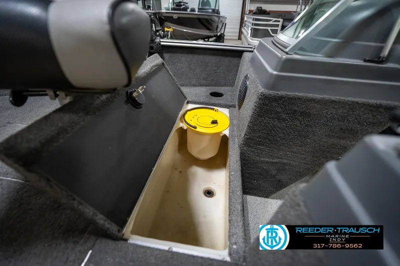Slide: The Image of 2014 Lund 1650 Rebel XS boat interior with storage compartment and yellow lid. - 31