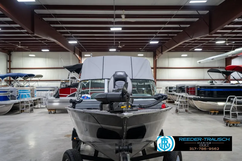 Slide: The Image of 2014 Lund 1650 Rebel XS boat in showroom, surrounded by other boats. - 5