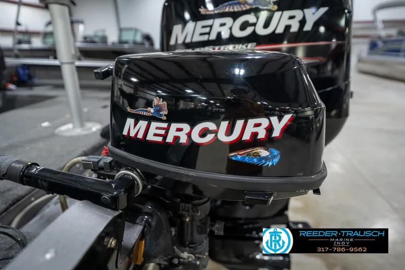Slide: The Image of 2014 Lund 1650 Rebel XS with Mercury outboard motor in a showroom setting. - 58