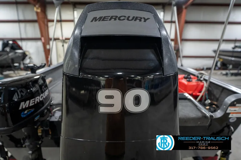 Slide: The Image of 2014 Lund 1650 Rebel XS with Mercury 90 engine in a boat showroom. - 62