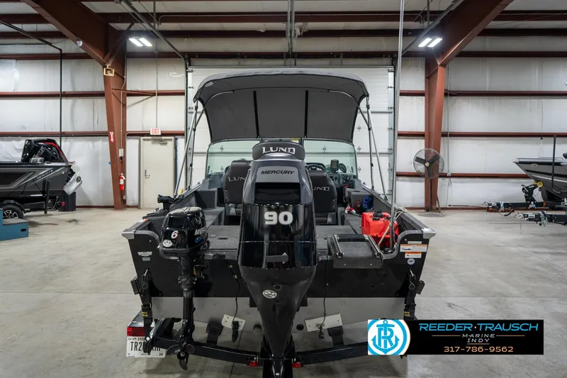 Slide: The Image of 2014 Lund 1650 Rebel XS boat in a warehouse, featuring Mercury outboard motor. - 9
