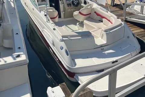 The Image of 2001 Chaparral 265 SSi boat docked, featuring white and red seating. - 1