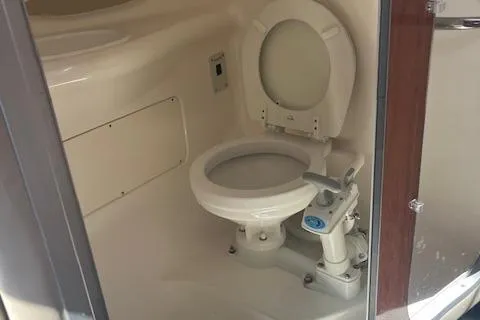 Slide: The Image of 2001 Chaparral 265 SSi boat bathroom with compact toilet and white interior. - 16