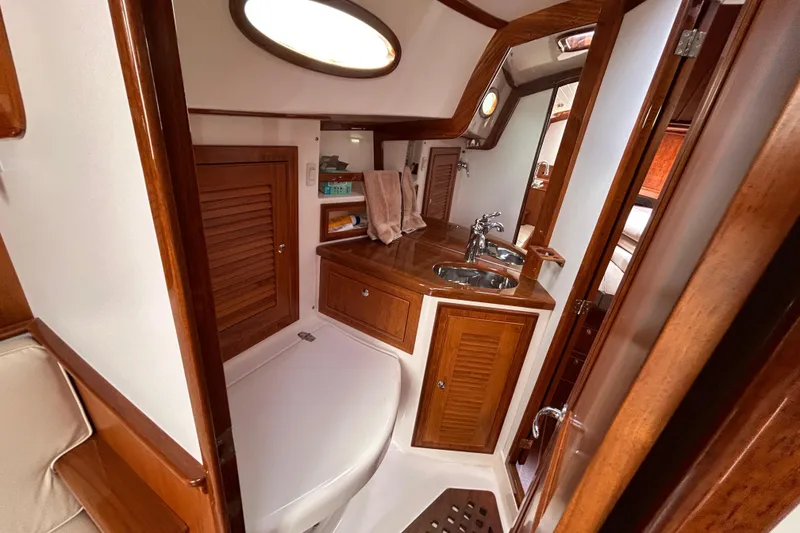 Slide: The Image of 2015 Alerion Coastal Cruiser interior with wooden cabinetry and compact bathroom. - 38
