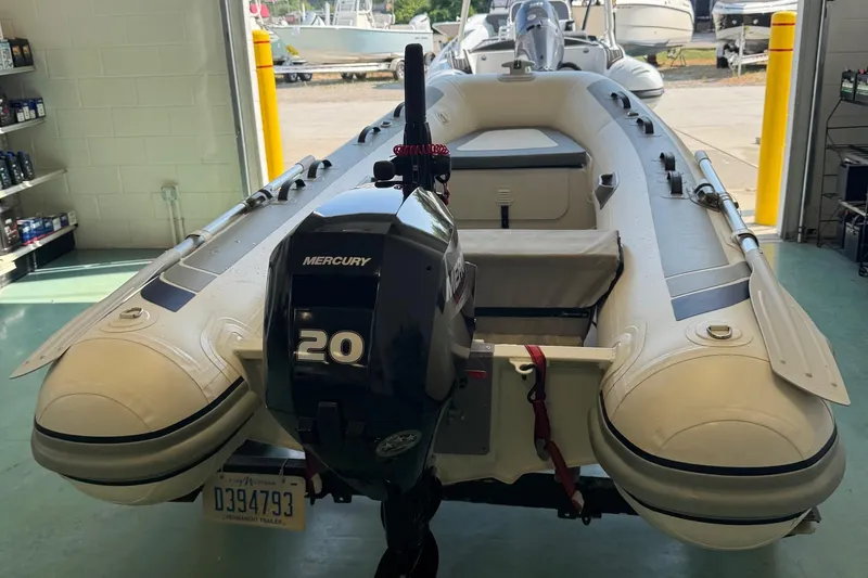 Slide: The Image of 2022 Highfield Classic 310 inflatable boat with Mercury 20 outboard motor in a garage. - 4