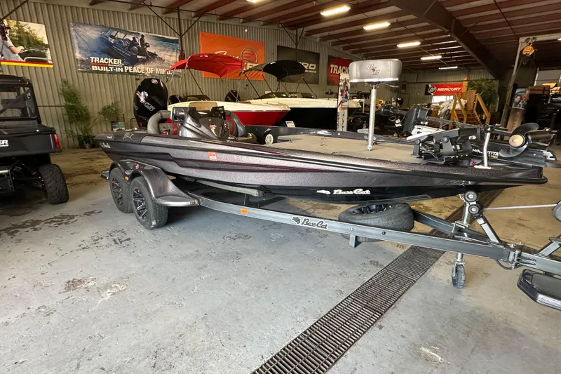Slide: The Image of 2021 Bass Cat Pantera II boat in showroom, on trailer, surrounded by other boats. - 12