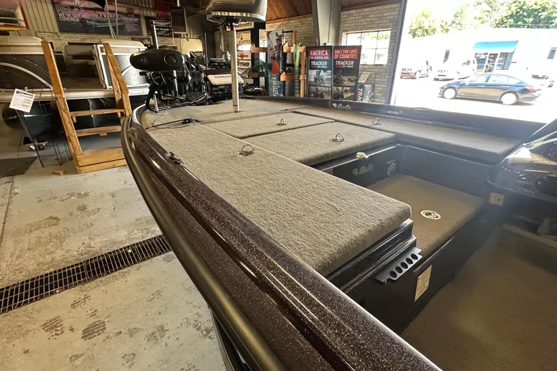 Slide: The Image of 2021 Bass Cat Pantera II boat interior in showroom, featuring carpeted deck and storage compartments. - 24
