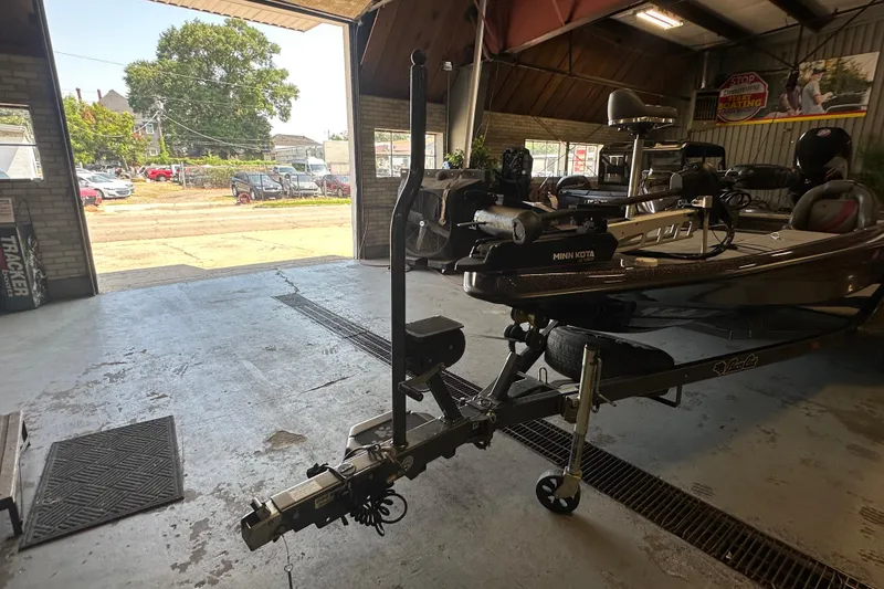 Slide: The Image of 2021 Bass Cat Pantera II boat in a garage, featuring a Minn Kota trolling motor. - 27
