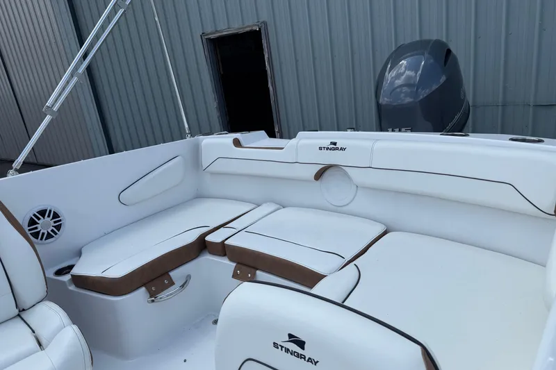 Slide: The Image of 2025 Stingray 172DC boat interior with white seating and brown accents. - 2