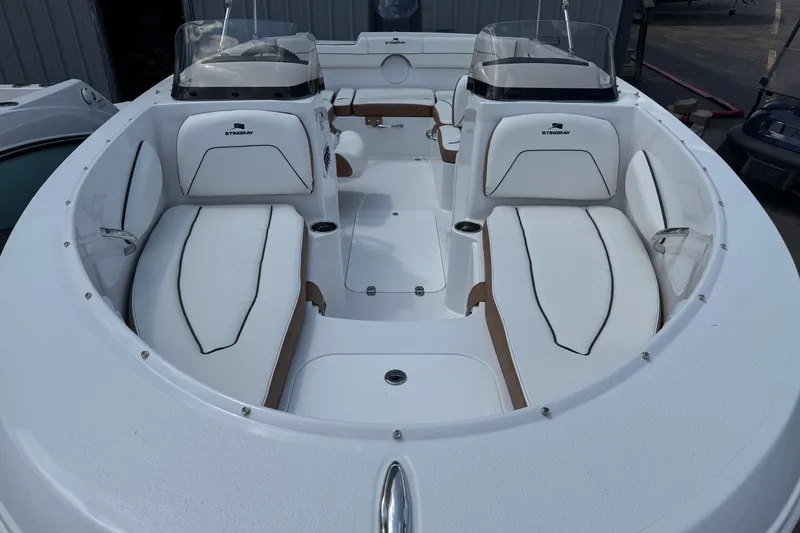 Slide: The Image of 2025 Stingray 172DC boat interior with white seating and dual consoles. - 4