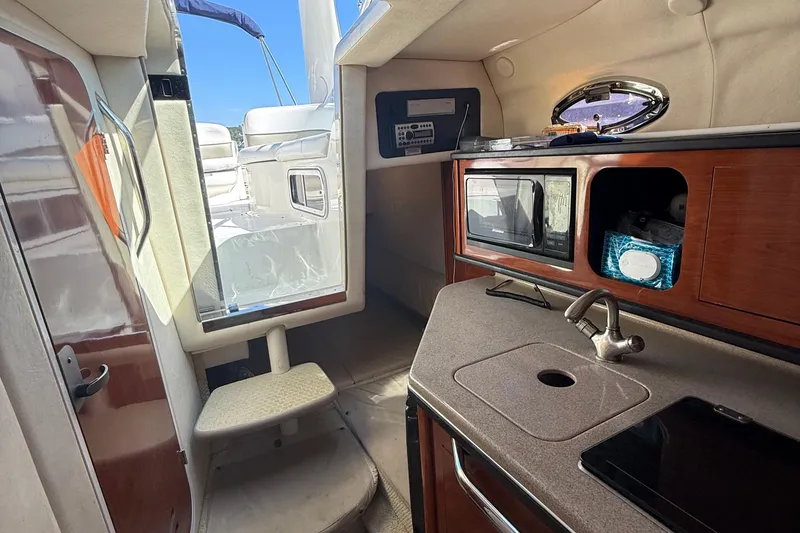 Slide: The Image of Interior of 2007 Sea Ray 260 Sundancer boat with kitchenette and seating area. - 12
