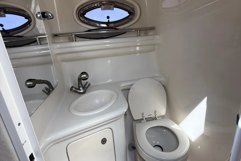 Slide: The Image of 2007 Sea Ray 260 Sundancer bathroom with sink, toilet, and porthole window. - 13