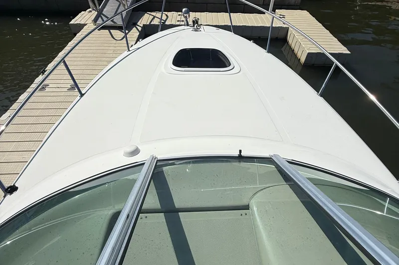 Slide: The Image of 2007 Sea Ray 260 Sundancer boat docked, view from bow, showing deck and railing. - 9